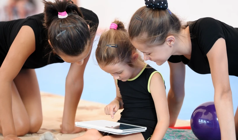 Three gymnast girls with tablet computer